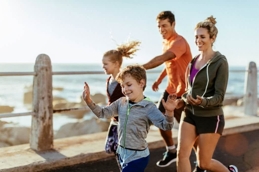 Active family jogging on a bridge for family health goals