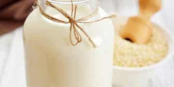 Quinoa milk benefits-bottle of quinoa milk on a table with a bowel of quinoa