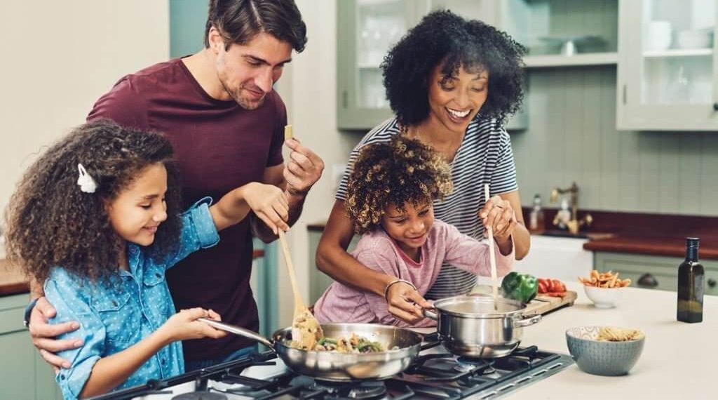 Parents and children cooking together in kitchen-activity family goals