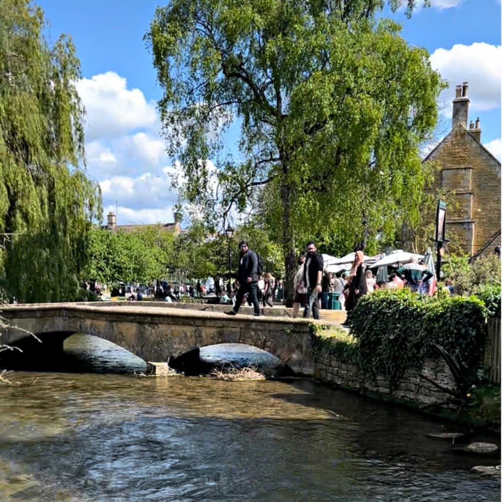 The rustling waters of river windrush spanned by one of the five historic arched bridges of bourton-on-the-water.