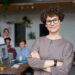 Manager lady smiling with employees in the background