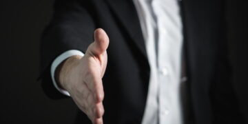 Man in black suit-showing hand to shake