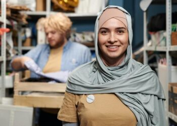 Volunteer woman in gray hijab smiling