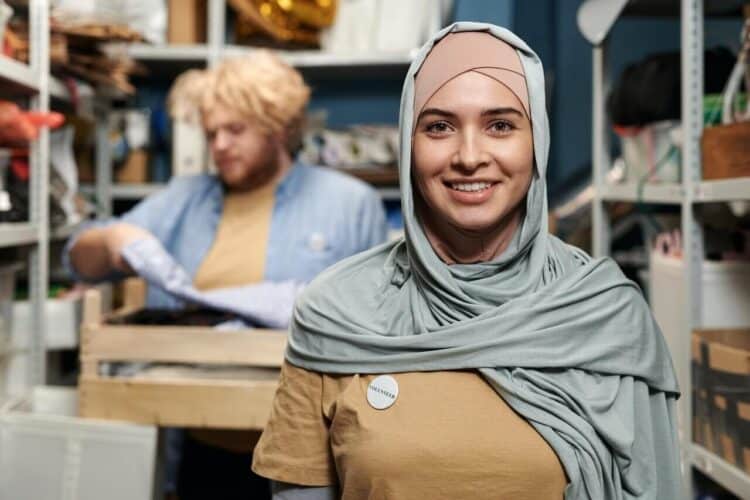 Volunteer woman in gray hijab smiling