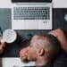 Man napping on his desk with silver laptop types of procrastination