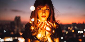Woman holding fireflies-what are the 4 laws of attraction
