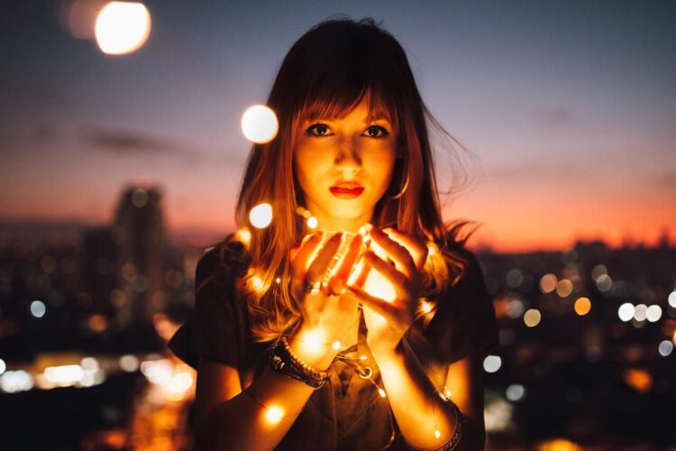 Woman holding fireflies-what are the 4 laws of attraction