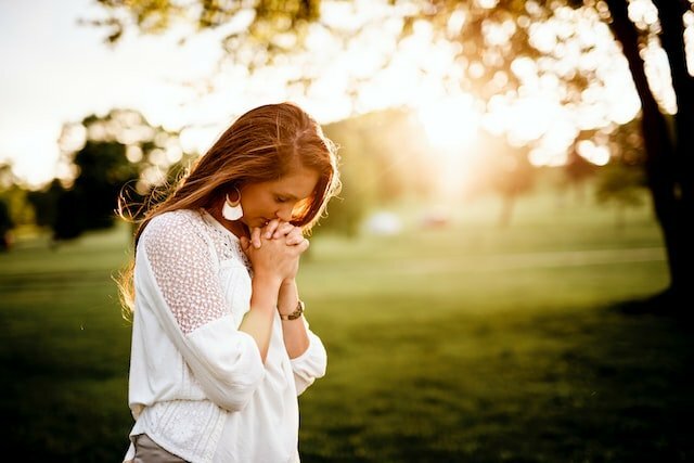 Woman in white dress praying in the field-dating timeline for single parents1