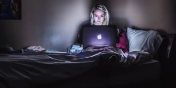 Woman sitting on lap with macbook on lap-jobs best for introverts
