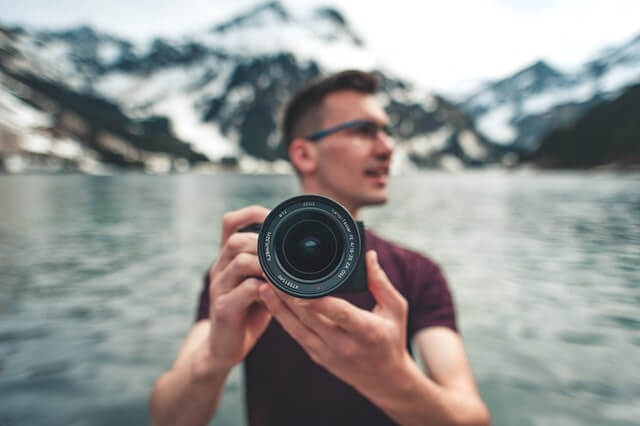 Photographer with camera with landscape in behind-travel photographer-jobs best for introverts
