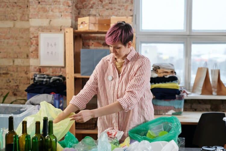 Middle-aged woman in pink shirt sorting out wastes for recycling-zero waste lifestyle