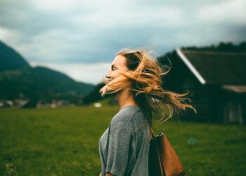 Middle aged woman outdoors with wind through her hair on her face-foods to avoid with osteoporosis
