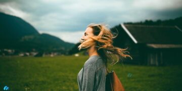 Middle aged woman outdoors with wind through her hair on her face-foods to avoid with osteoporosis