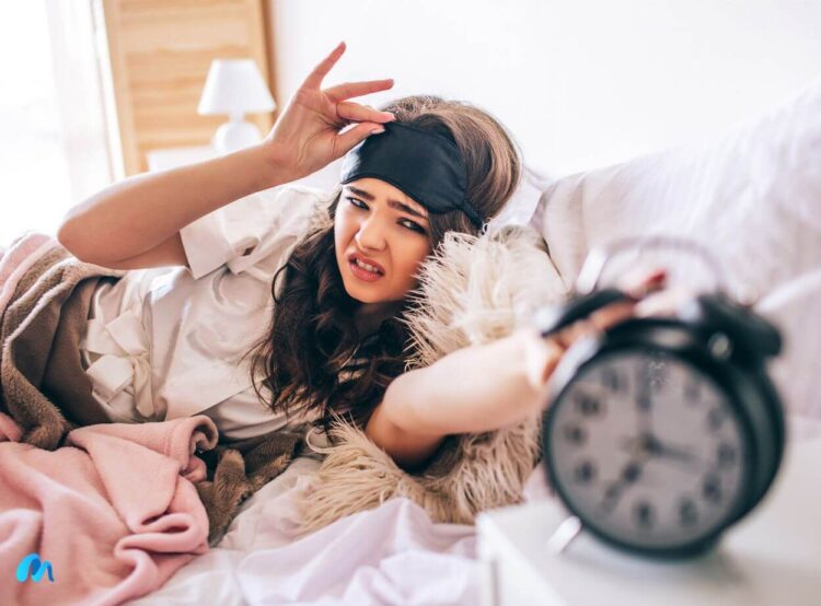 Dark haired beautiful young brunette wake up in her bed and reaching out to the alarm clock-reasons why lazy people are more likely to be successful