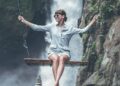 Beautiful woman swings near waterfall in the jungle of bali island-living your truth