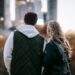 Relationships-young couple looking towards the city landscape on a cold sunny day