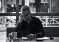 Man in black jacket sitting at table