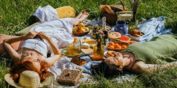 Women lying on green grass field-does lying down after eating make you fat