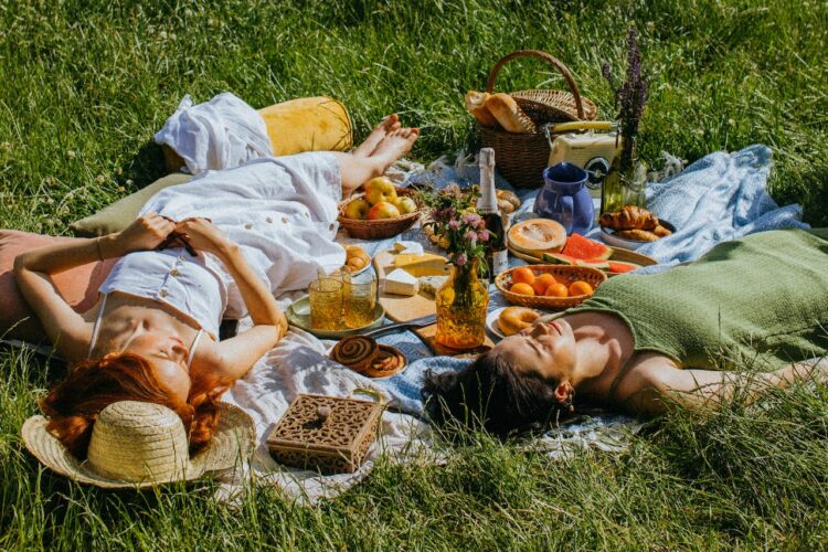 Women lying on green grass field-does lying down after eating make you fat