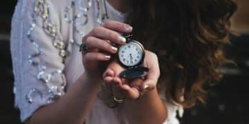 Woman holding black pocket watch at 5:30-no more waiting, its time