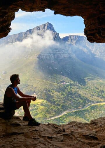 Photo of man sitting on a cave -the world owes you nothing