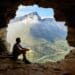 Photo of man sitting on a cave -the world owes you nothing