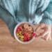 Person holding white ceramic bowl with red and yellow beans-i ate oatmeal every morning for a month-here's what happened